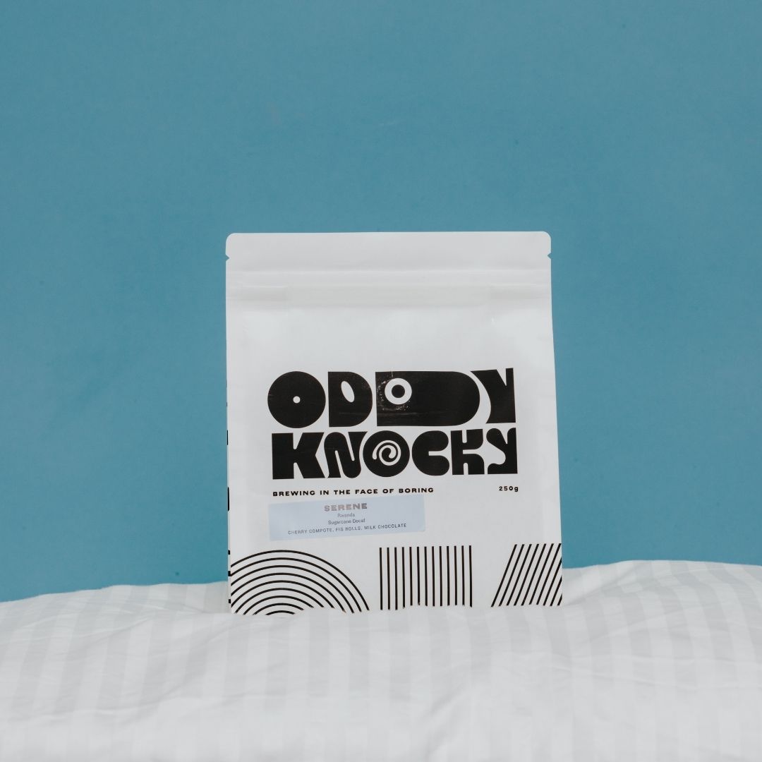 Packaging of Serene Decaf Coffee from Rwanda featuring unique graphic design on a blue background.
