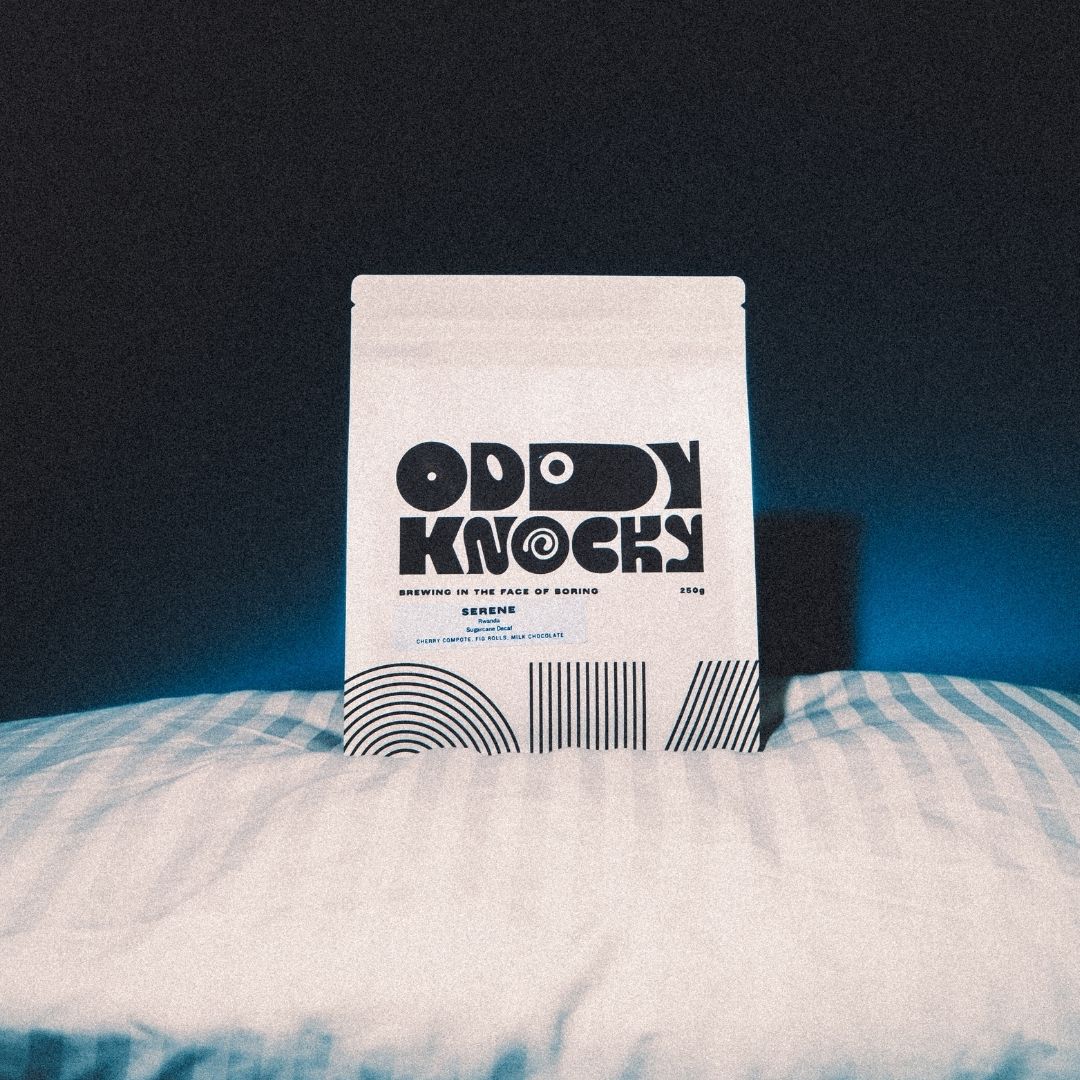 Serene Decaf Coffee bag on a pillow, featuring unique design and branding, showcasing its Rwanda origin and tasting notes.