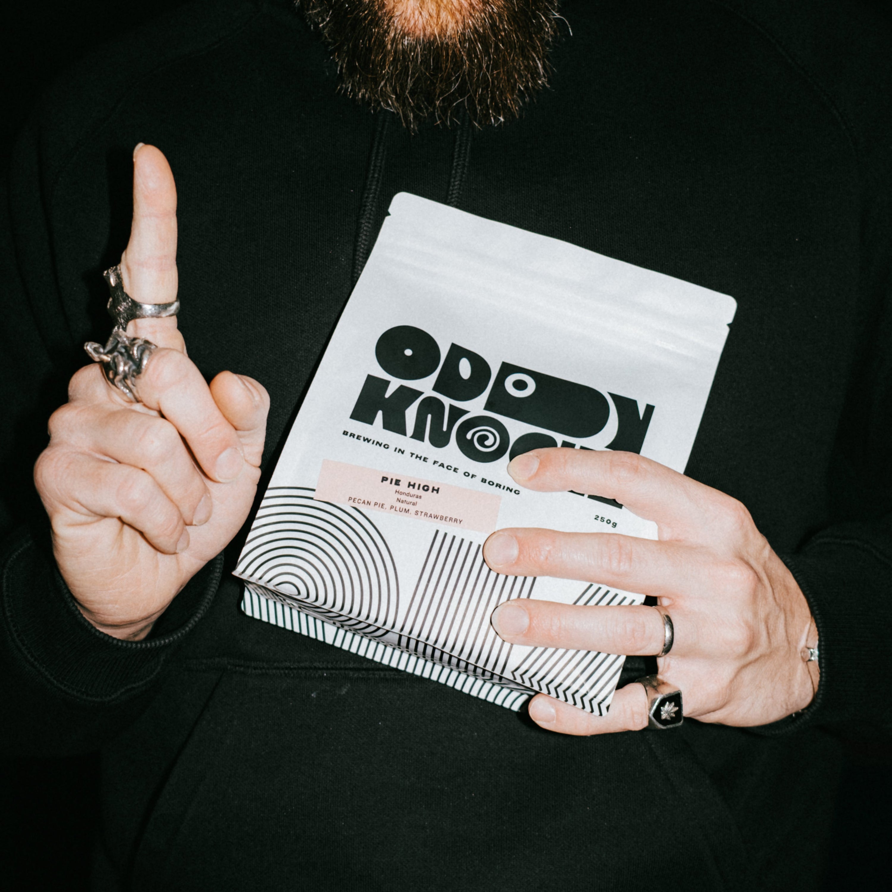 Prepaid Espresso Subscription bag held by a person with rings, showcasing modern coffee packaging design.