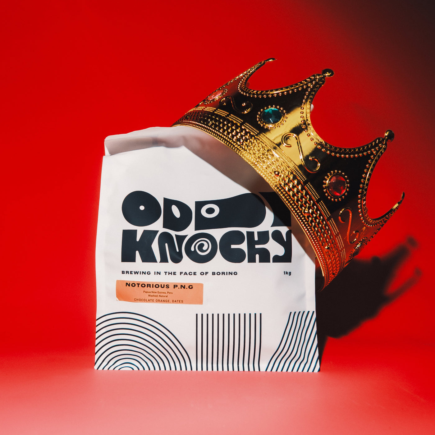 The Notorious P.N.G. coffee bag with a golden crown on a red background, featuring chocolate orange and dates.