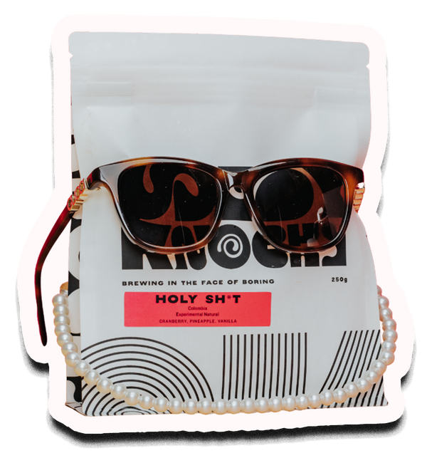 Holy Sh*t Cranberries coffee bag, wearing a pearl necklace and gucci glasses