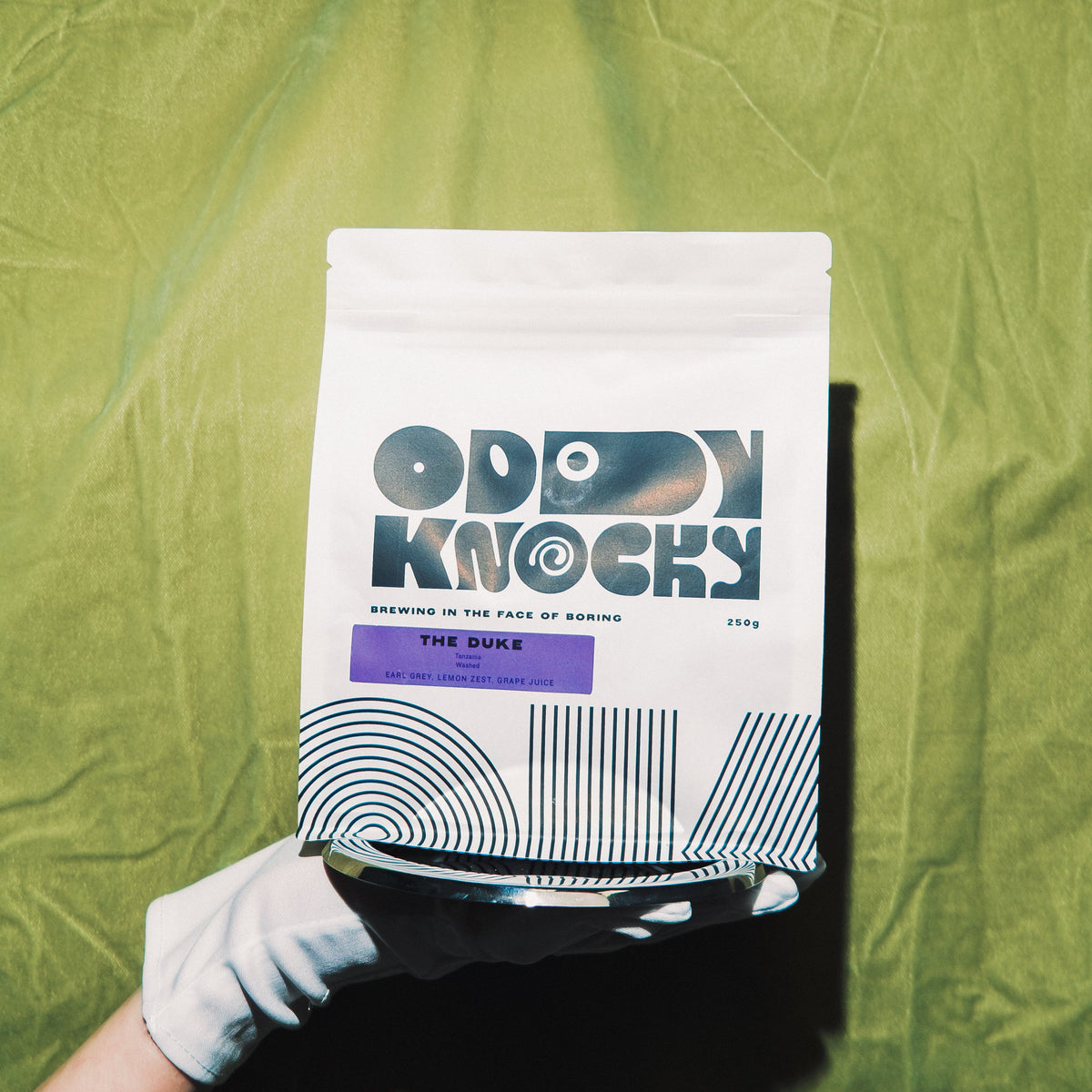 The Duke Tanzania coffee package with earl grey and lemon zest notes, on vibrant background.